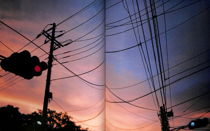 Interior spread of HIROMIX / Hikari with Silhouettes of power lines and a traffic light against a sunset sky.