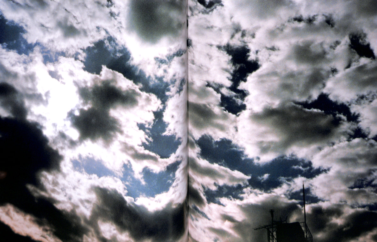 Interior spread of HIROMIX / Hikari with Two side-by-side images of a cloudy sky with a sunlit area.