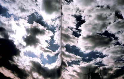 Interior spread of HIROMIX / Hikari with Two side-by-side images of a cloudy sky with a sunlit area.