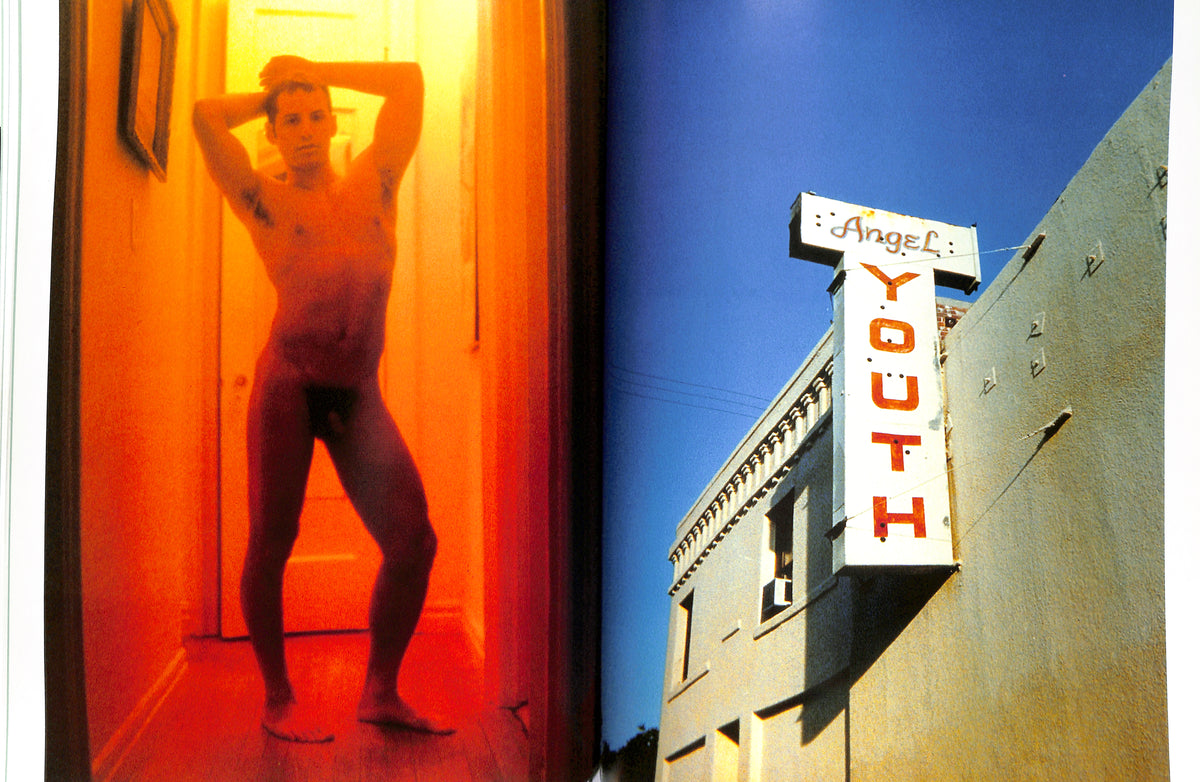 Internal shot odPerson in a red-lit room with 'Angel Youth' sign outside buildingf NAN GOLDIN, DAVID ARMSTRONG, MARK MORRISROE, JACK PIERSON, PHILIP-LORCA diCORCIA / Emotions & Relations. 