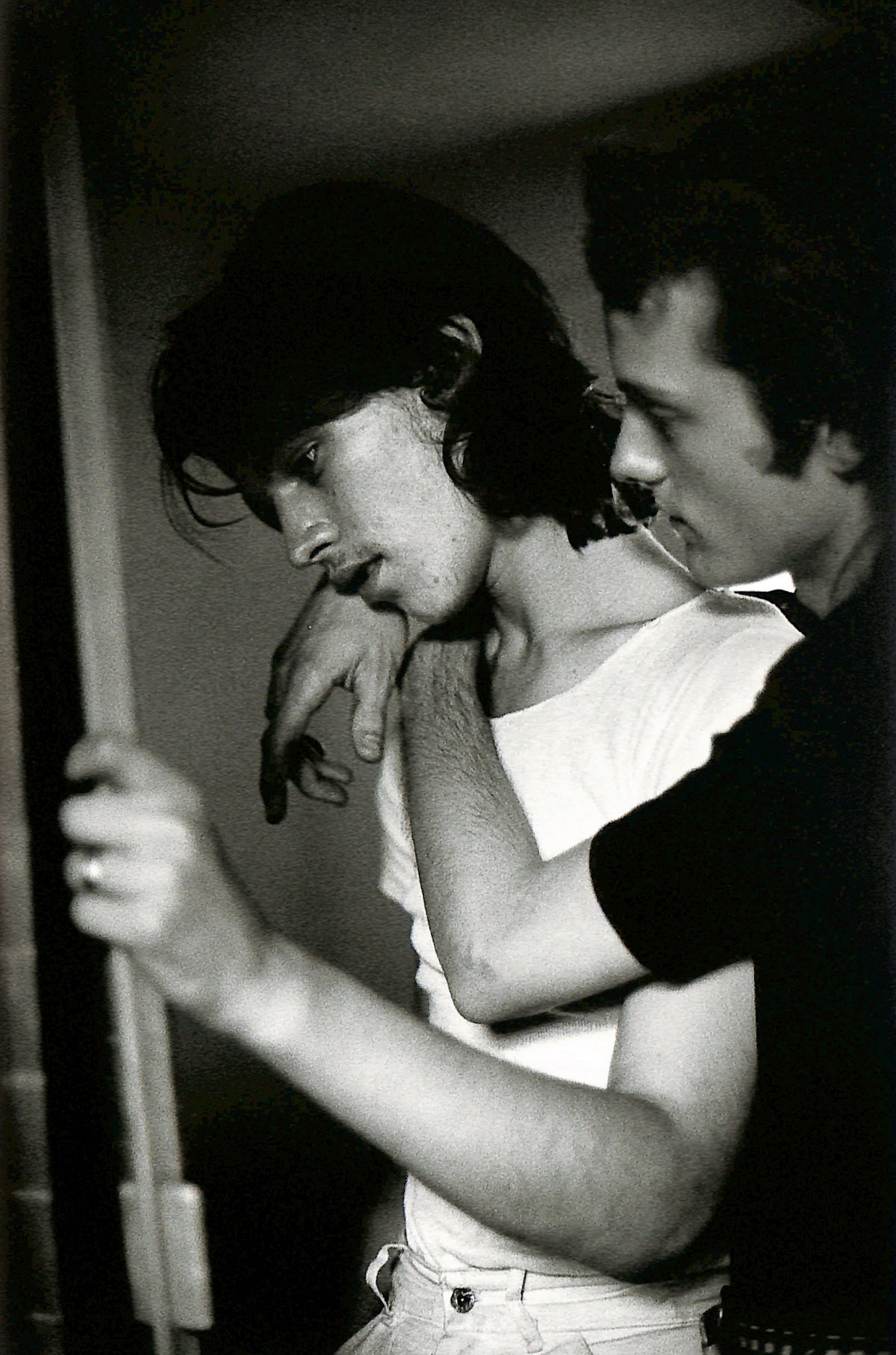 Interior image - NAN GOLDIN / COUPLES AND LONELINESS. Black and white photo of two people embracing, one with a tattoo on their arm.