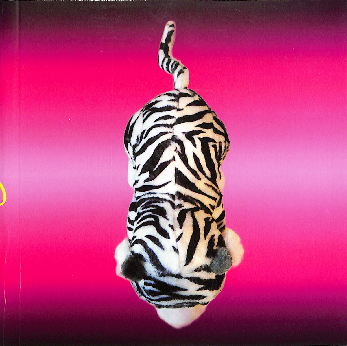 Zebra-striped plush toy on a pink background